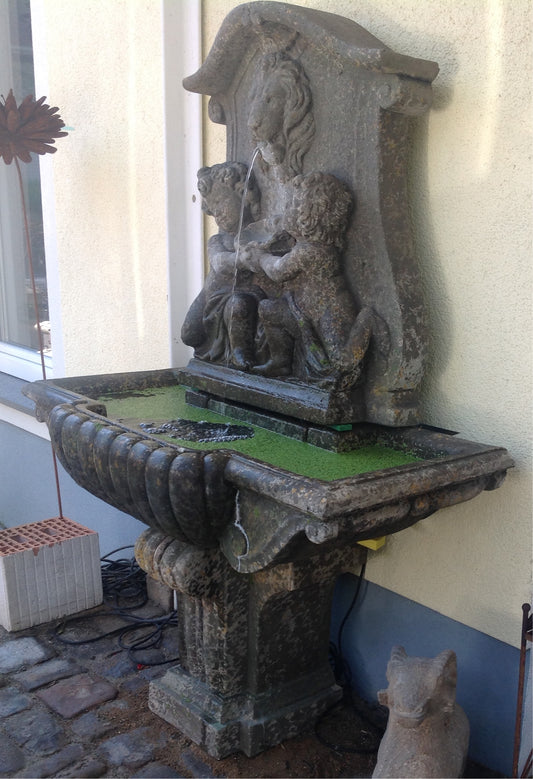 Wandbrunnen mit Löwenkopf und Engelsputen